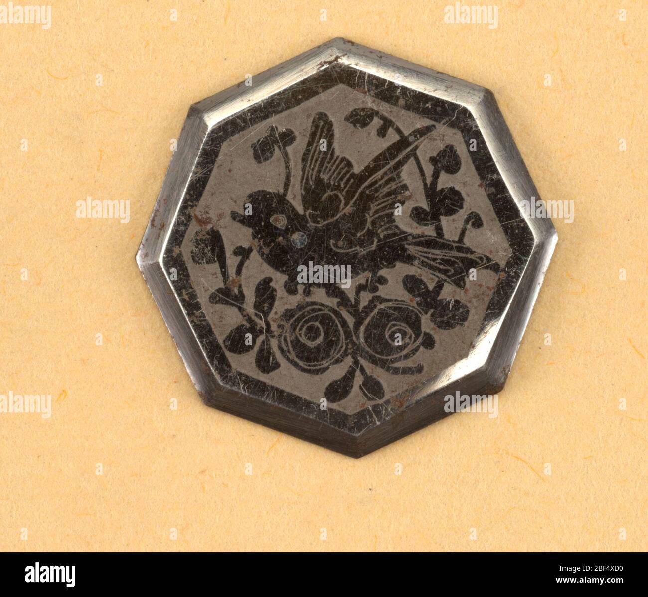 Button. Eight-sided flat buttons ornamented with design of a bird and a flowering spray in steel, on a dull ground.Component -c is on Cooper Union Exhibition card 8 Stock Photo