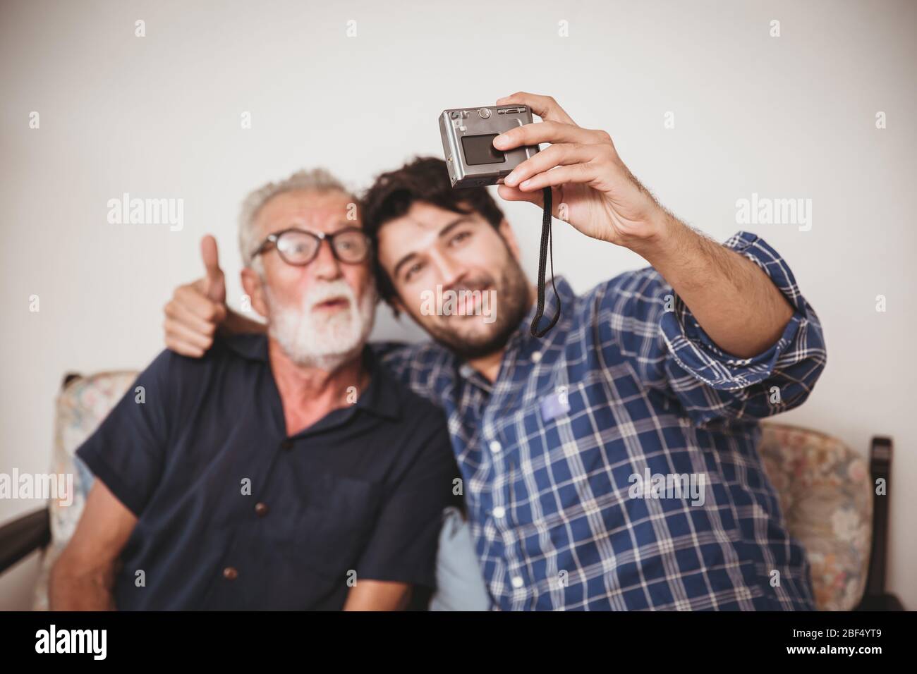 Happy elder, Son take a photo selfie with his uncle happy family with digital camera lifestyle. Stock Photo