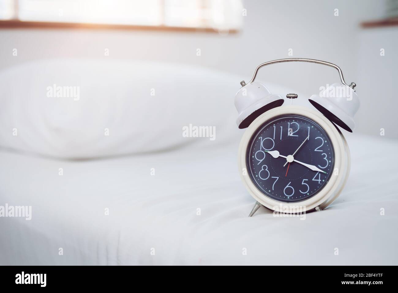 Bed time clock in the morning with space for text Stock Photo