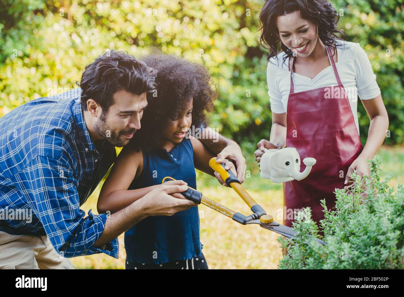 Happy family holiday activity during stay at home parent at backyard gardening with children. Stock Photo