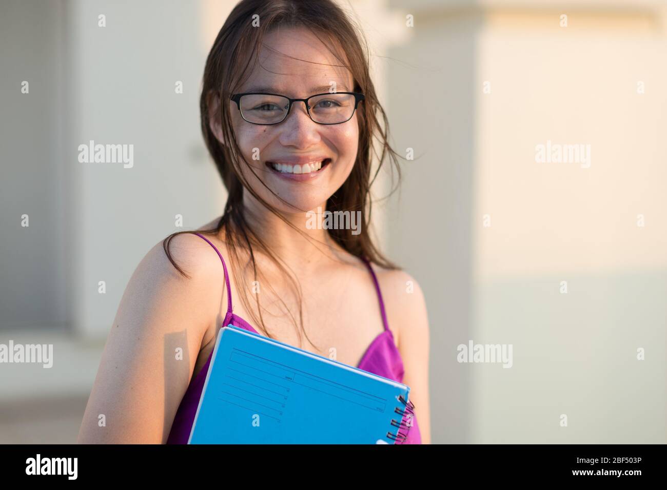 Female student walking on campus smiling Stock Photo Alamy