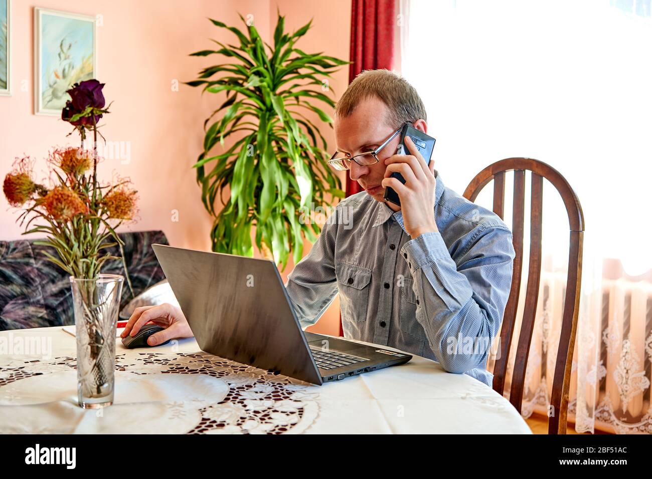 Man talking with phone and working in home office. Stock Photo