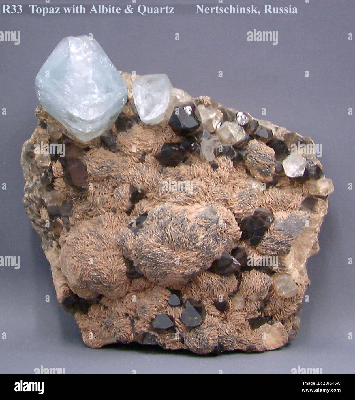 Rock matrix with small crystals and orange and clear topaz with white  background Stock Photo - Alamy