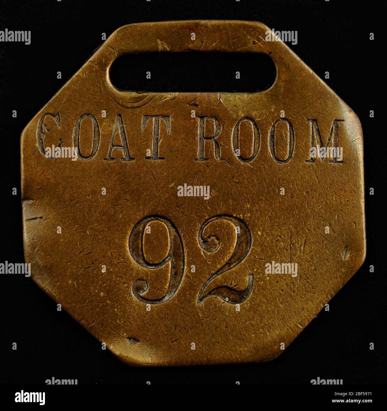 Coat Room Owney tag. The locations of some of the tags Owney received on his journeys are impossible to track down. This octagonal metal tag is marked simply “COATROOM 92” and offers no clues to its origin. Stock Photo