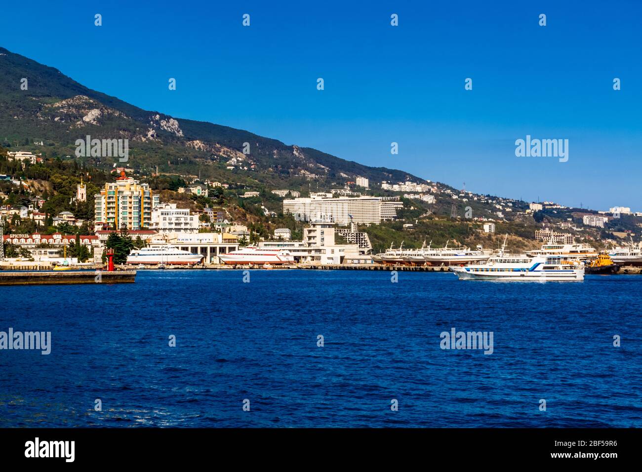 Yalta, Crimea, Russia - 05 October 2015: Marine pleasure ship in the Yalta Bay on the background of the Intourist Hotel Stock Photo