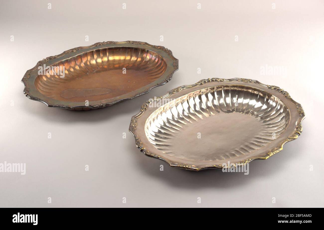 Pair of platters. Oval bowls with fluted cavetto. Flat marly with raised edge and a decorated with single and symmetrically opposed acanthus leaves. Stock Photo