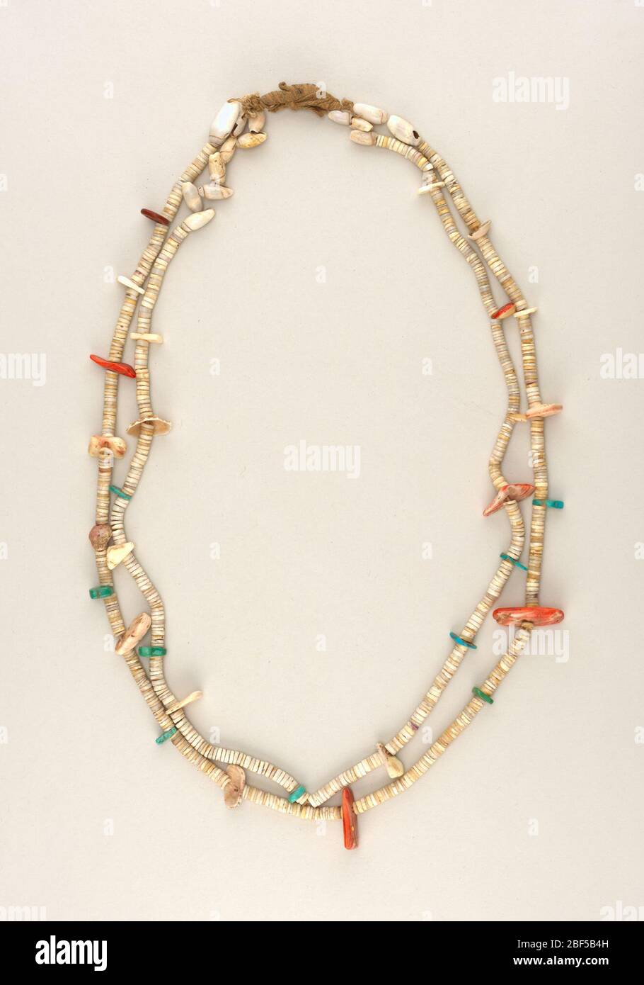 Necklace. Necklace of two strands made of shell discs, whole shells, and larger pieces of turquoise and red stones strung on leather. Stock Photo