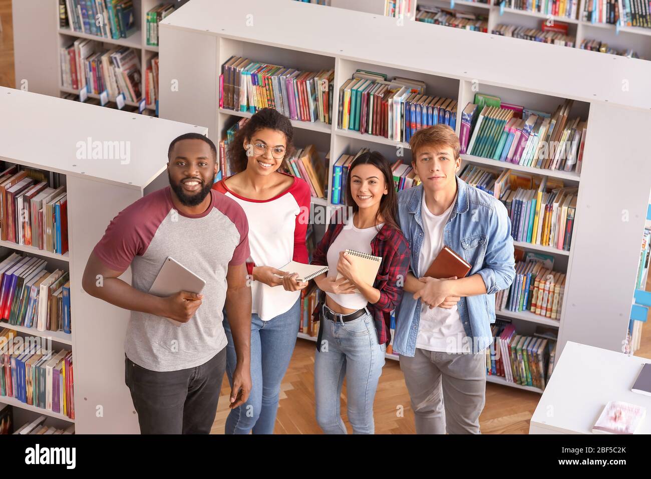 Group Of Young Students In Library Stock Photo - Alamy