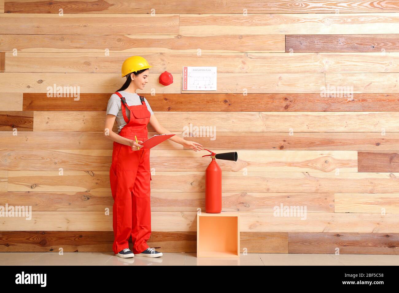 Fire safety specialist inspecting extinguisher Stock Photo