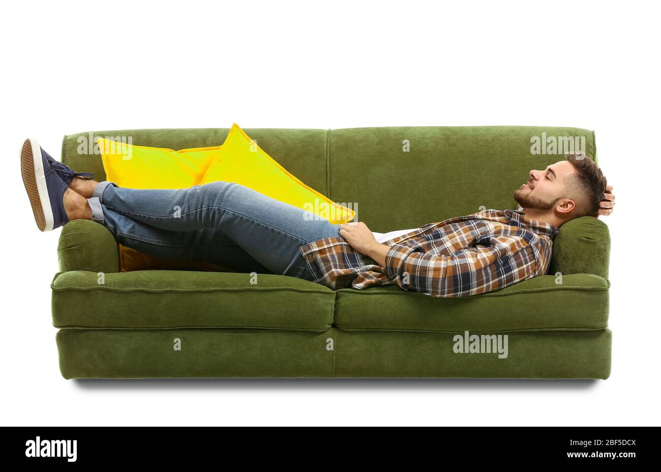 Young man relaxing on sofa against white background Stock Photo