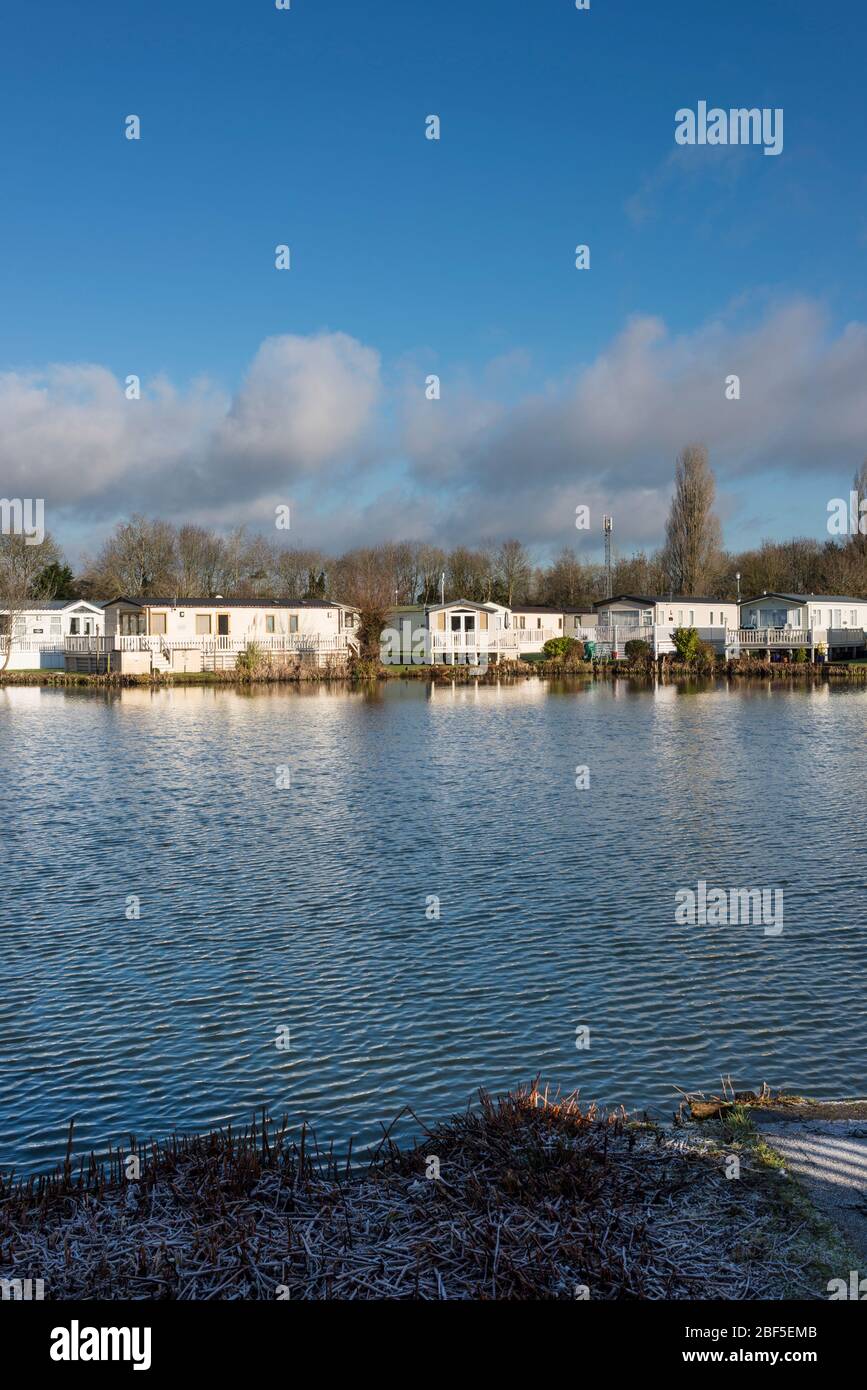 Static caravans by lake in Cotswold Water Park, South Cerney, Gloucestershire, UK Stock Photo