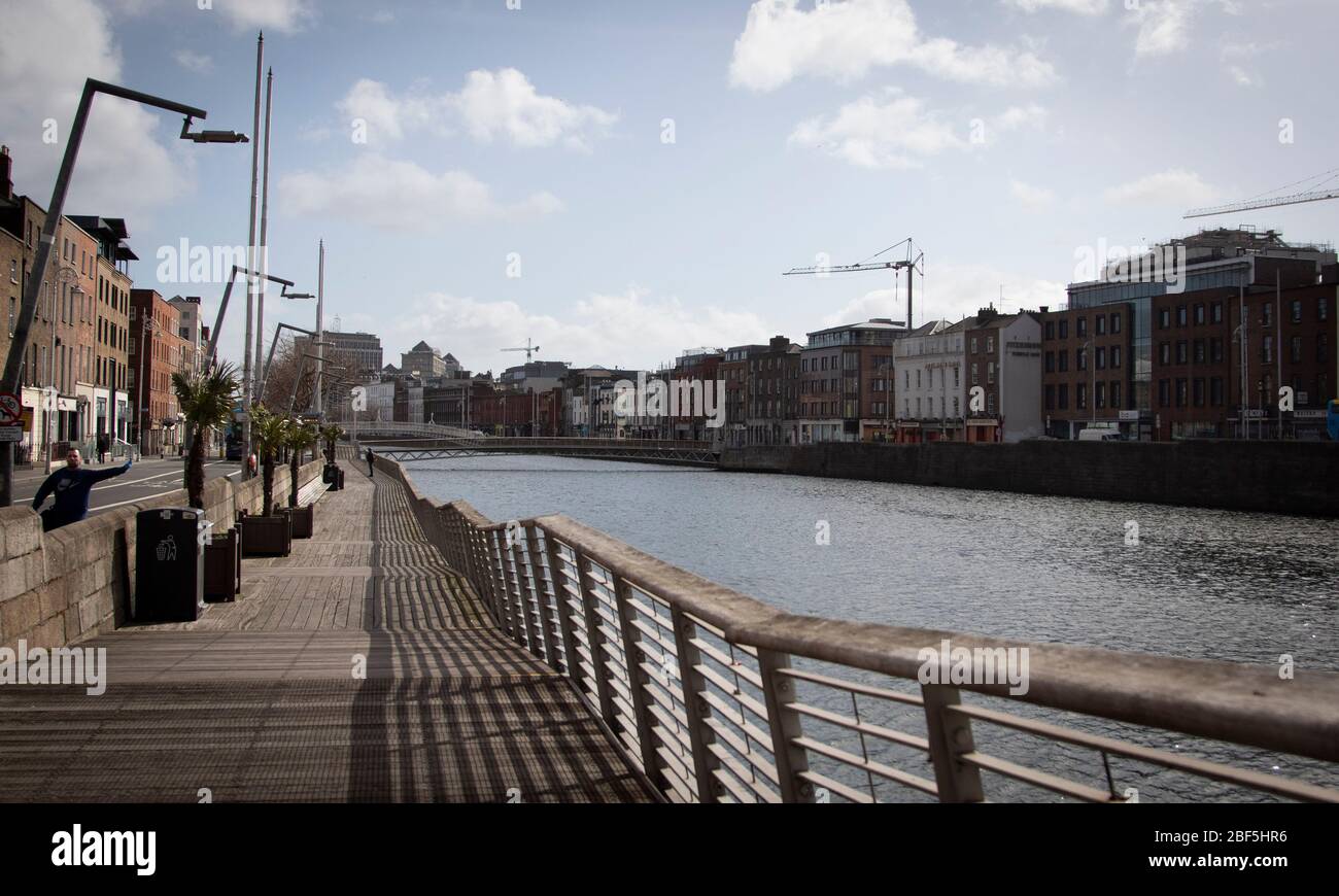 Dublin, Ireland - April 6, 2020: the normally bustling boardwalk along the river Liffey now practically deserted due to Covid-19 lockdown restrictions. Stock Photo