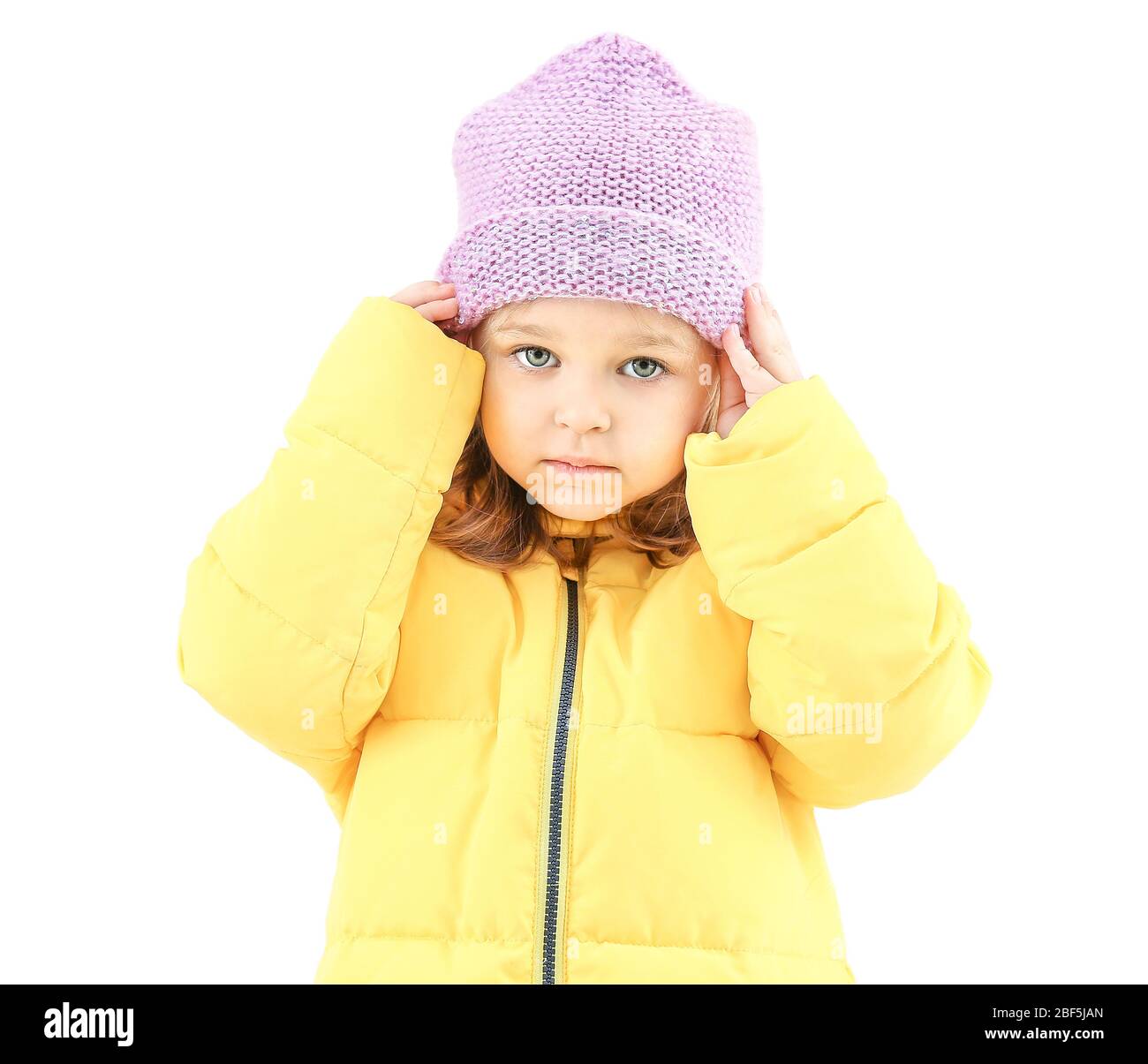 Cute little girl in winter clothes on light background Stock Photo Alamy