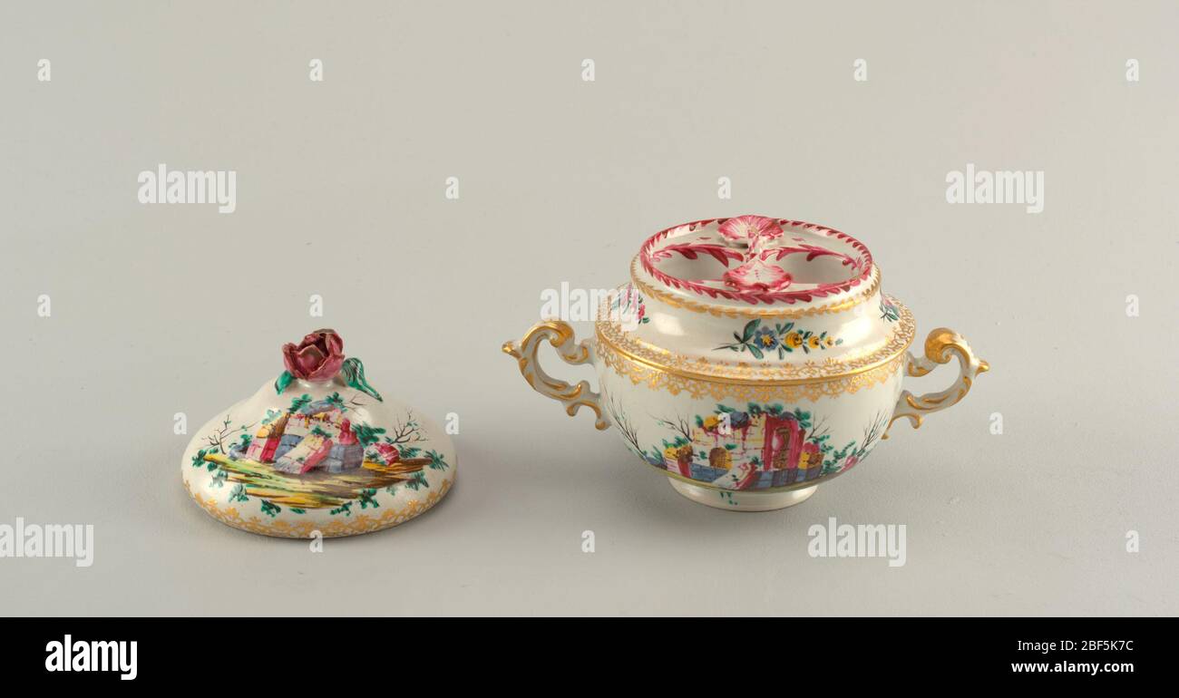 Egg cup. Two handled cup with two round openings at top. Decorated with scenes of ruins, flowers and gilding. Cover decorated with scenes of ruins and a floral finial. Stock Photo