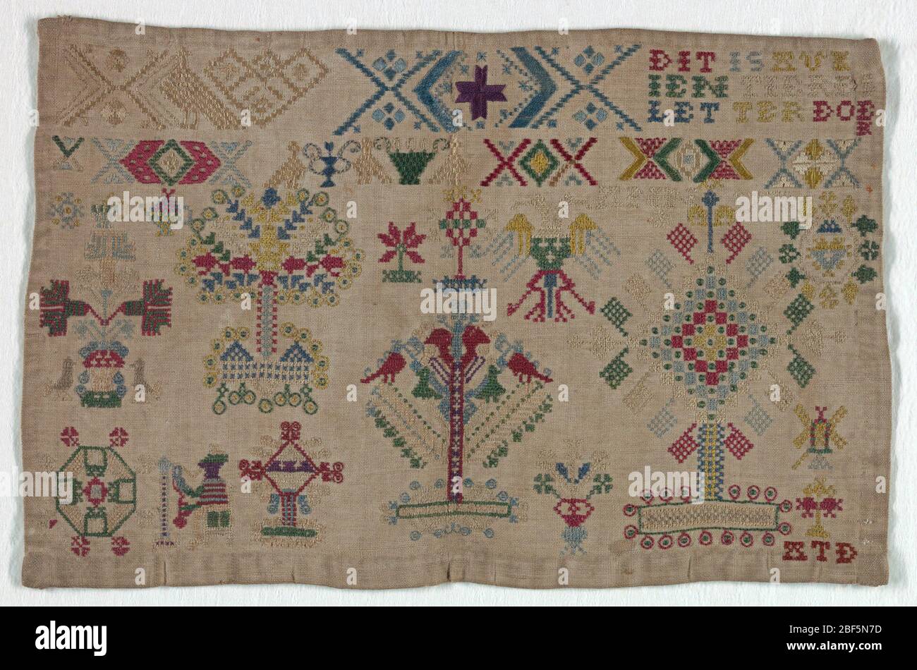 Sampler. Bands of patterning, lettering at upper left and motifs including a spinning monkey and Hapsburg double-headed eagle. Stock Photo