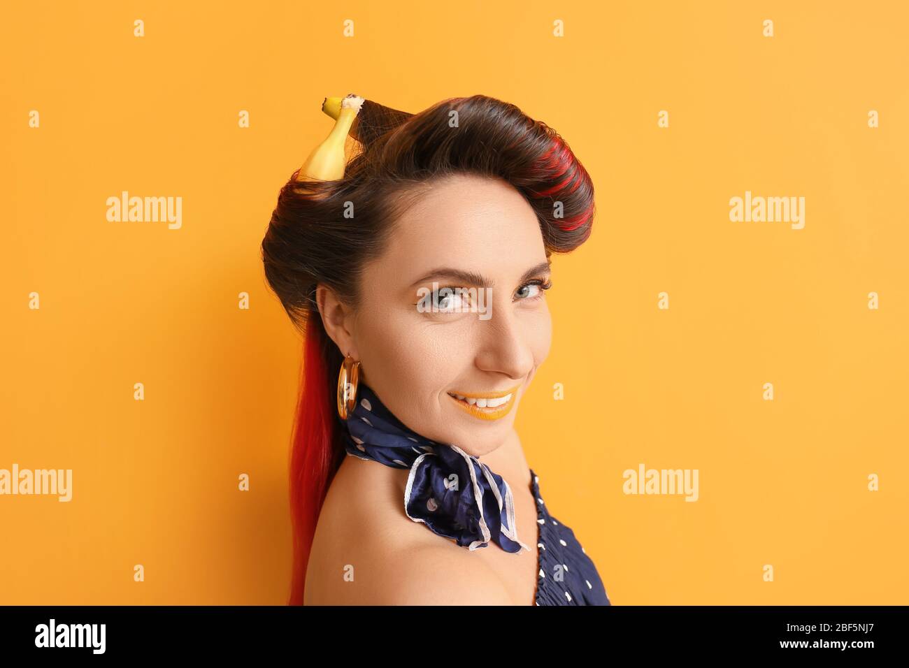 Beautiful woman with bananas in her hair on color background Stock ...