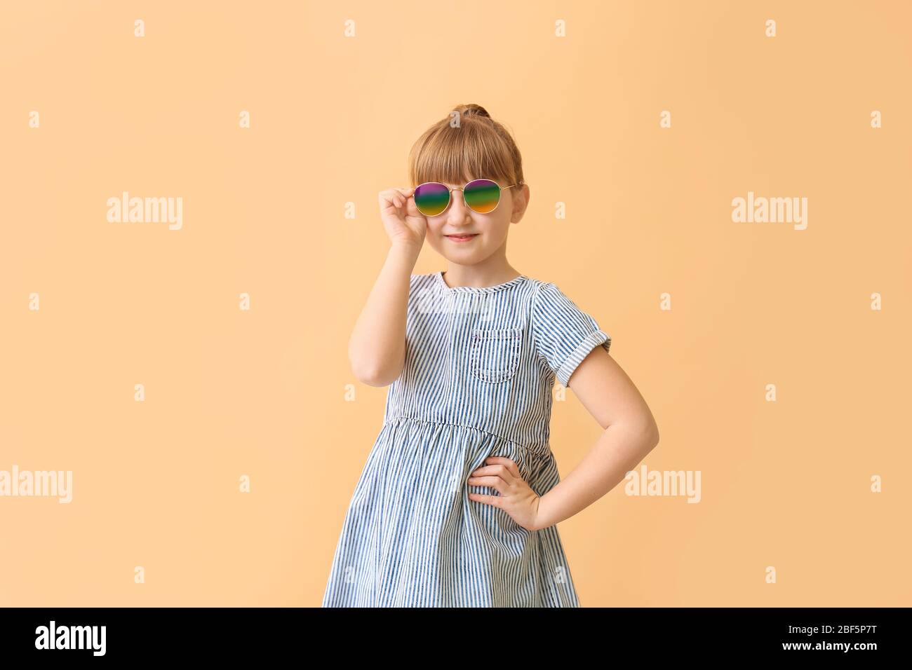 Funny little girl with sunglasses on color background Stock Photo Alamy
