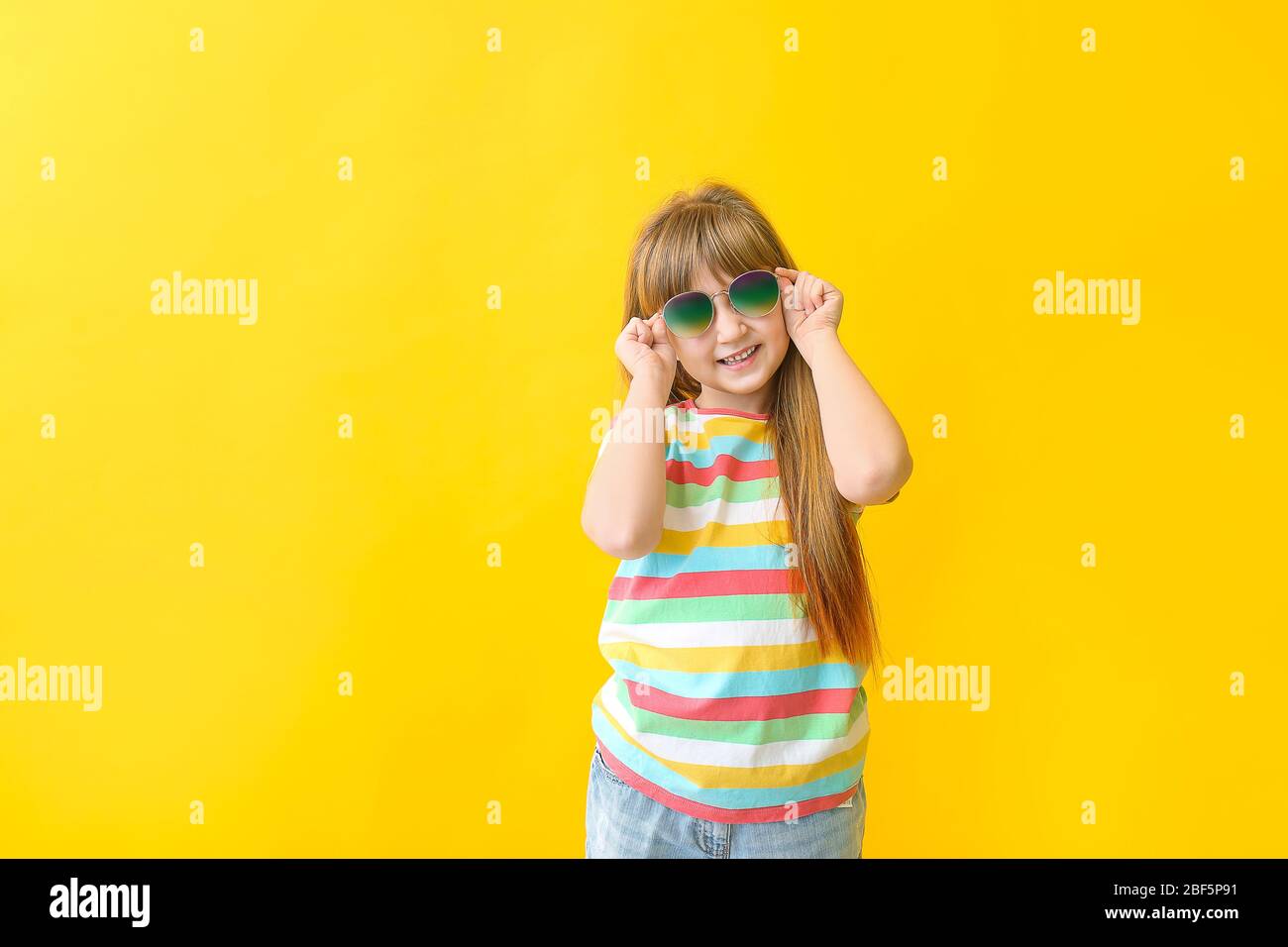 Funny little girl with sunglasses on color background Stock Photo Alamy