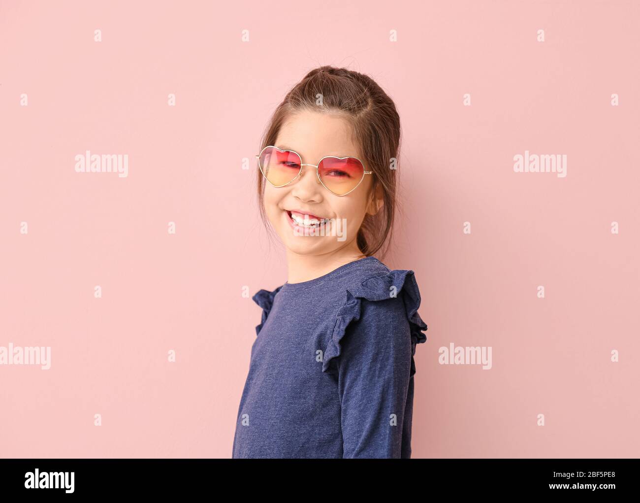 Funny little girl with sunglasses on color background Stock Photo Alamy