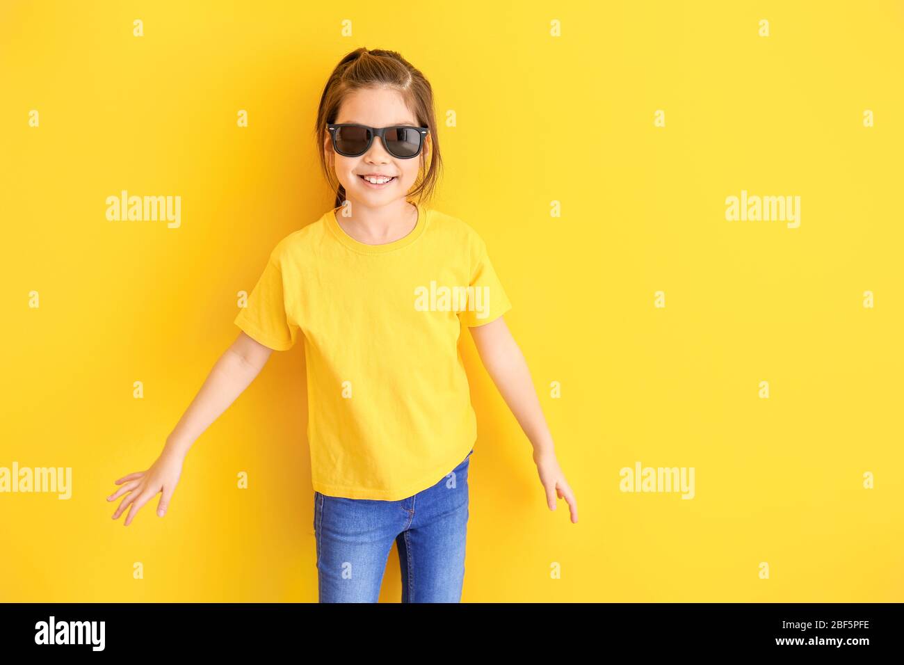 Funny little girl with sunglasses on color background Stock Photo Alamy
