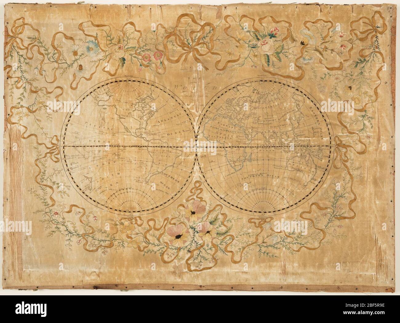 Map sampler. Embroidery on top of printed satin foundation of two globes of the world. Printing on satin reads: 'The World with all modern boundaries.' Elaborate border of embroidered flowers and ribbons. Stock Photo