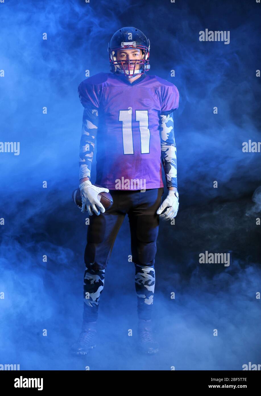 American football player in smoke on dark background Stock Photo Alamy