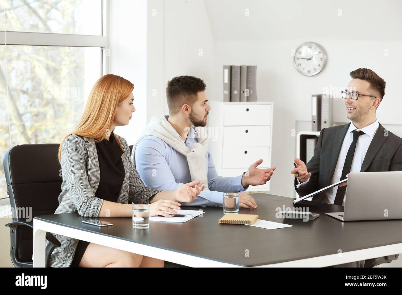 Bank manager working with displeased clients in office Stock Photo - Alamy