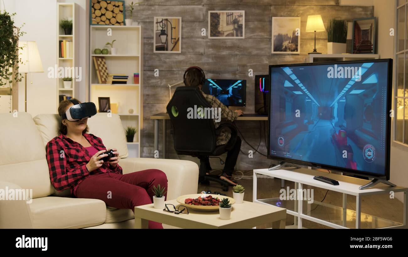 Woman experiencing virtual reality while playing video games using vr headset. Game over for female gamer. Stock Photo