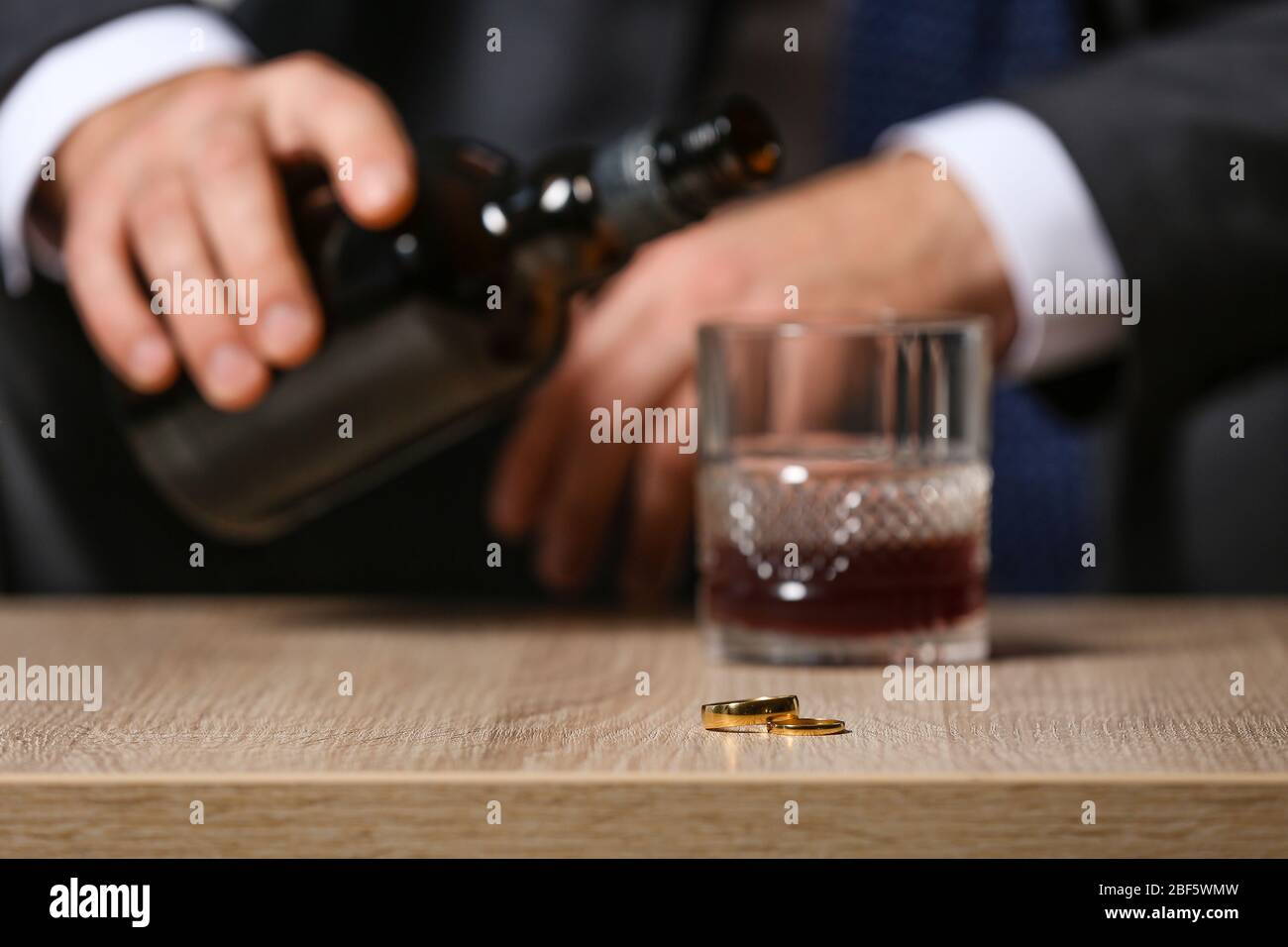 Divorced man drinking cognac at home. Concept of alcoholism Stock Photo