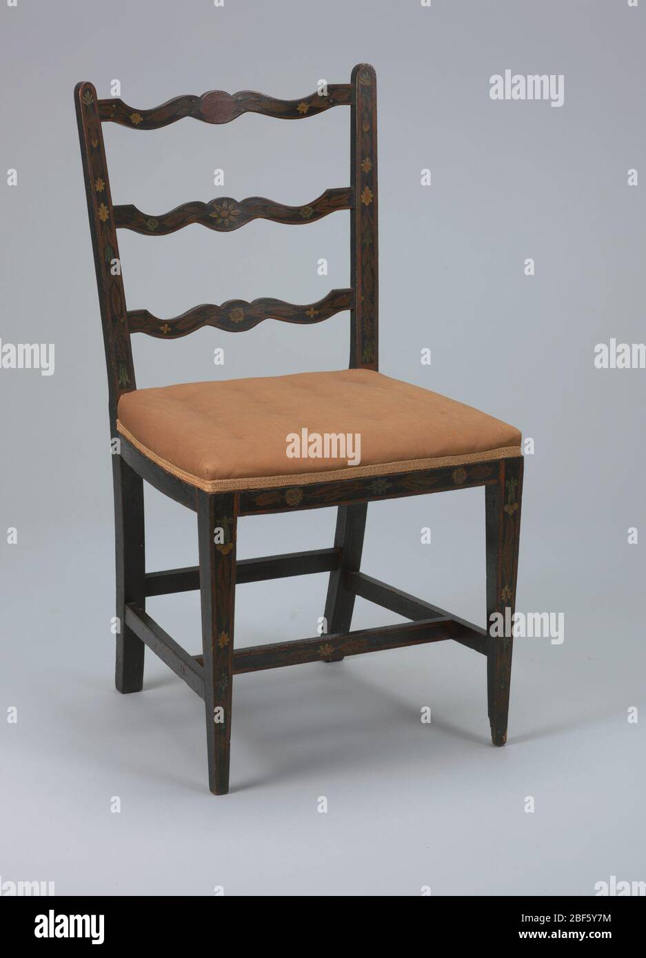 Side chair. Three, curvilinear-shaped splats characterize back. Upper posts are tapered. Two lateral and two longitudinal stretchers. Upholstered seat (light pink). Stock Photo