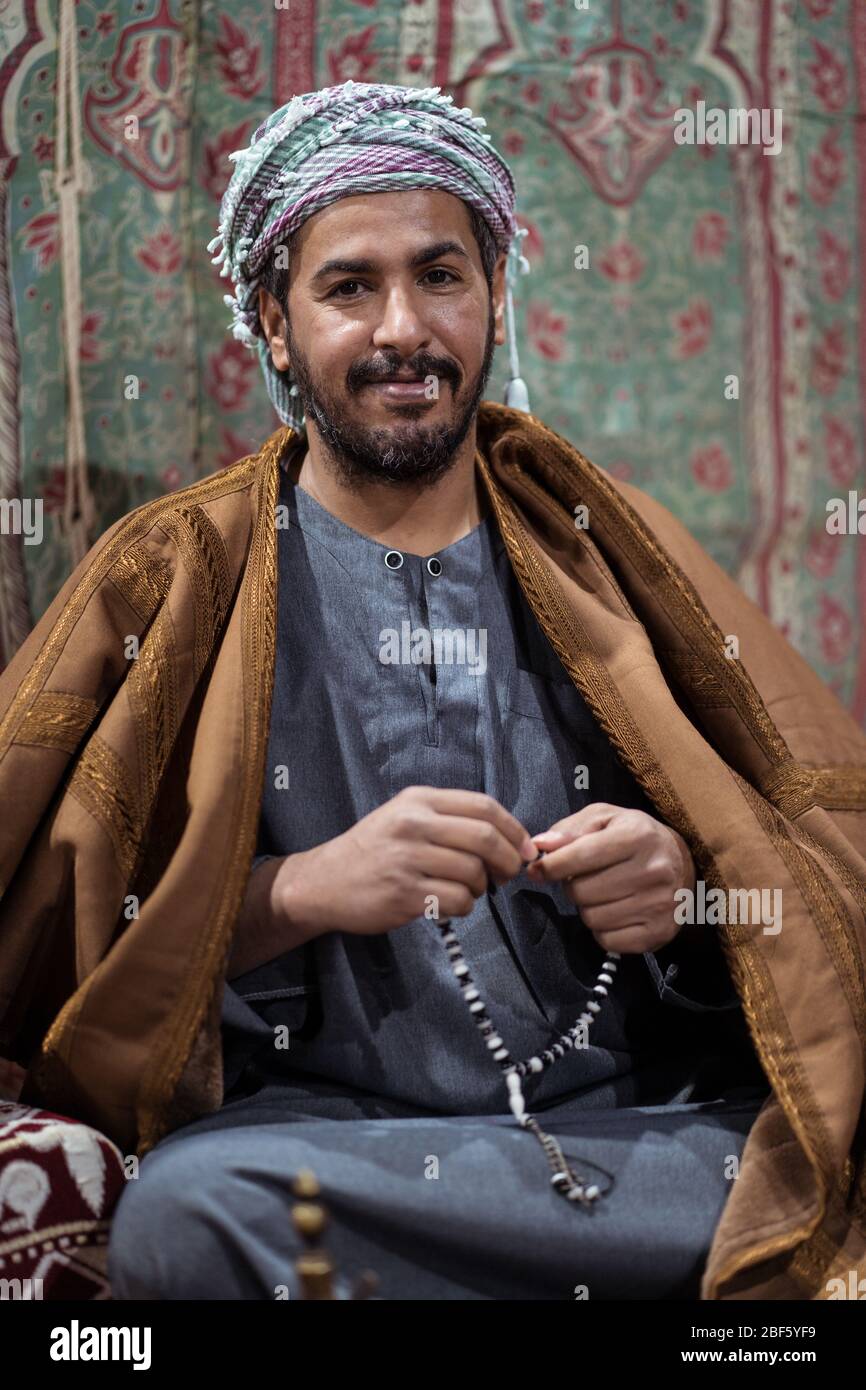 Portrait of Bedouin man wearing traditional clothes praying with a