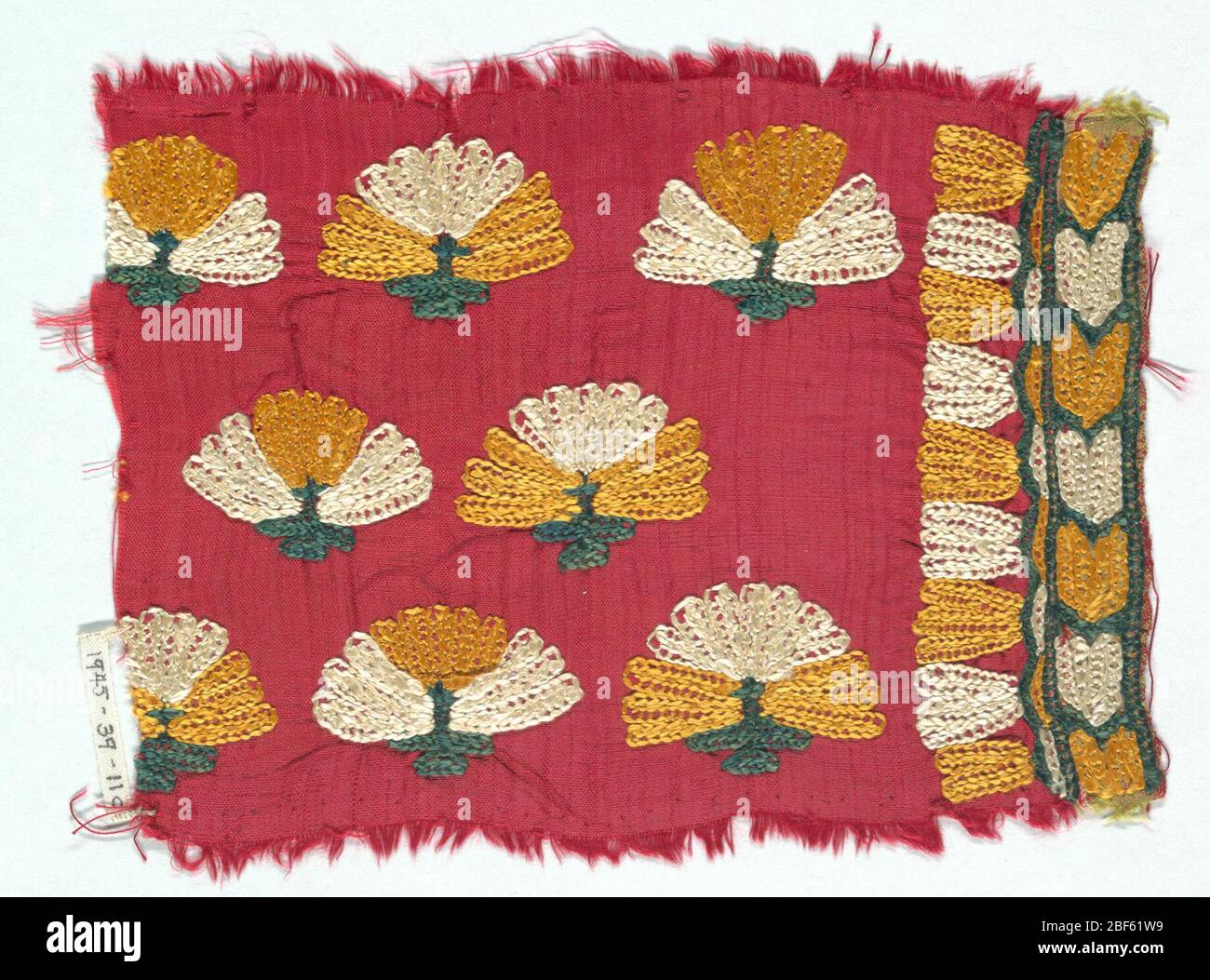 Fragment. Red ground fabric with embroidery in yellow, green and white