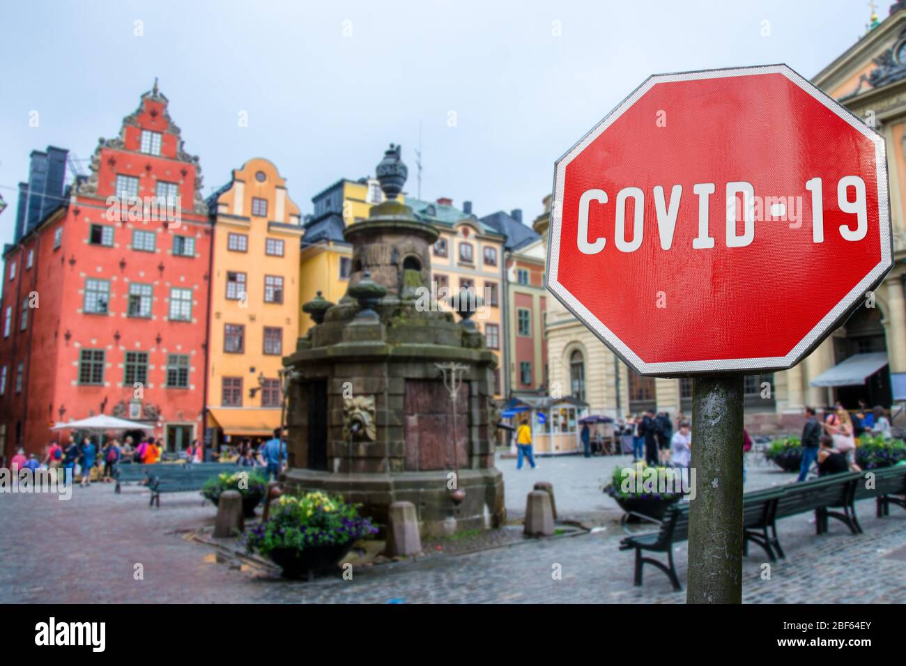 Corona virus stop sign with view of historic old town in Stockholm, Sweden. Warning about epidemic quarantine. Coronavirus disease pandemic. COVID-19 Stock Photo