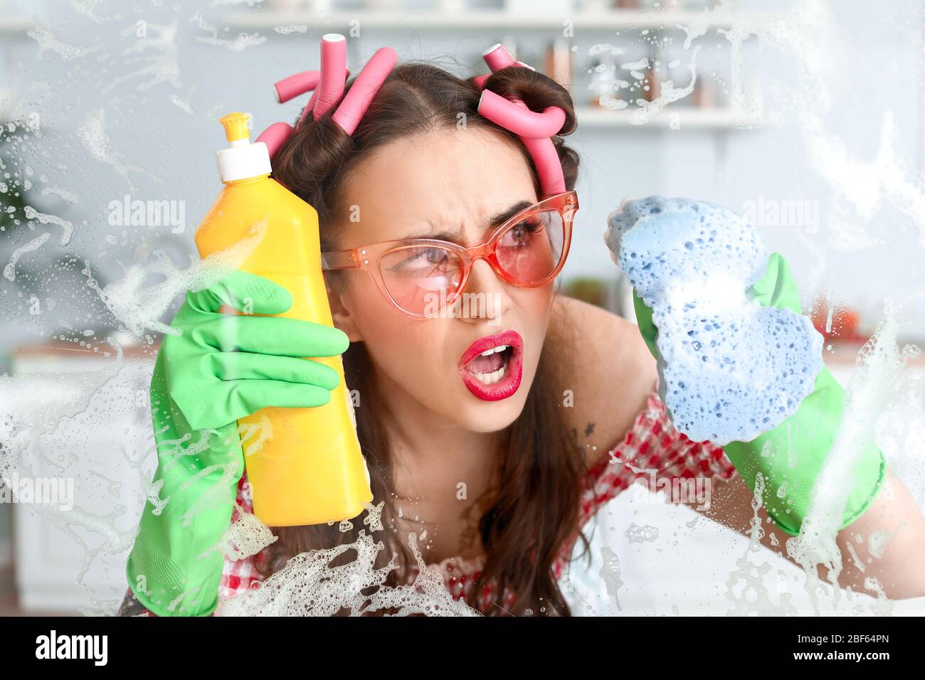 Funny angry housewife cleaning kitchen window Stock Photo - Alamy