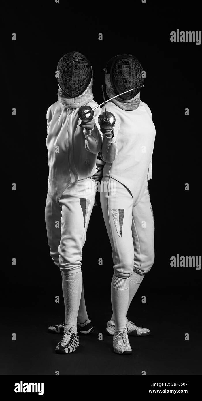 Young fencers on dark background Stock Photo