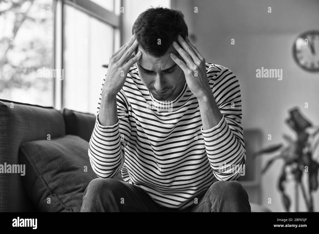 Black and white portrait of depressed young man at home Stock Photo