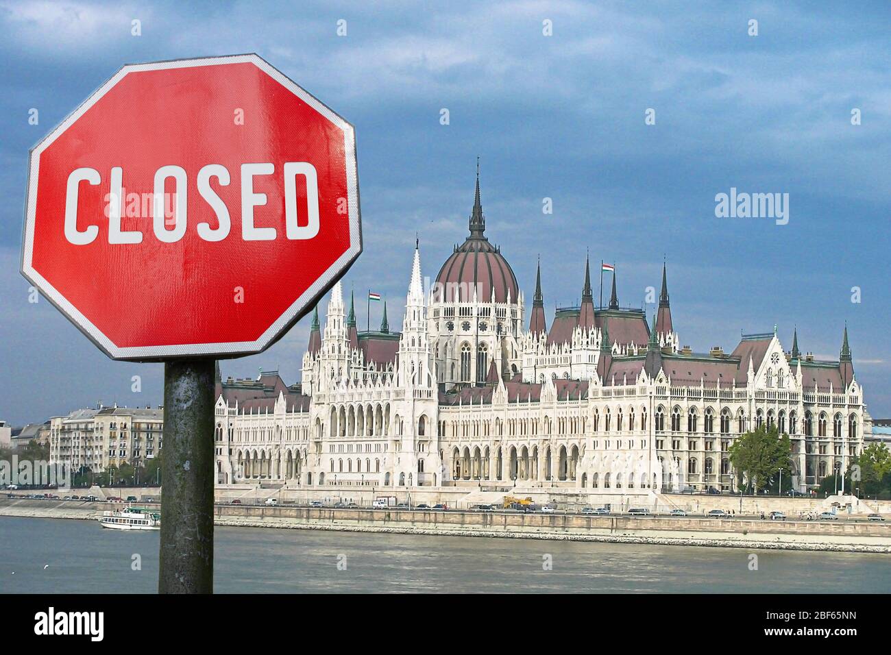 Closed, close stop sign with Budapest parliament in Hungary. Closed facilities because of corona virus. COVID-19 pandemic quarantine. Stock Photo