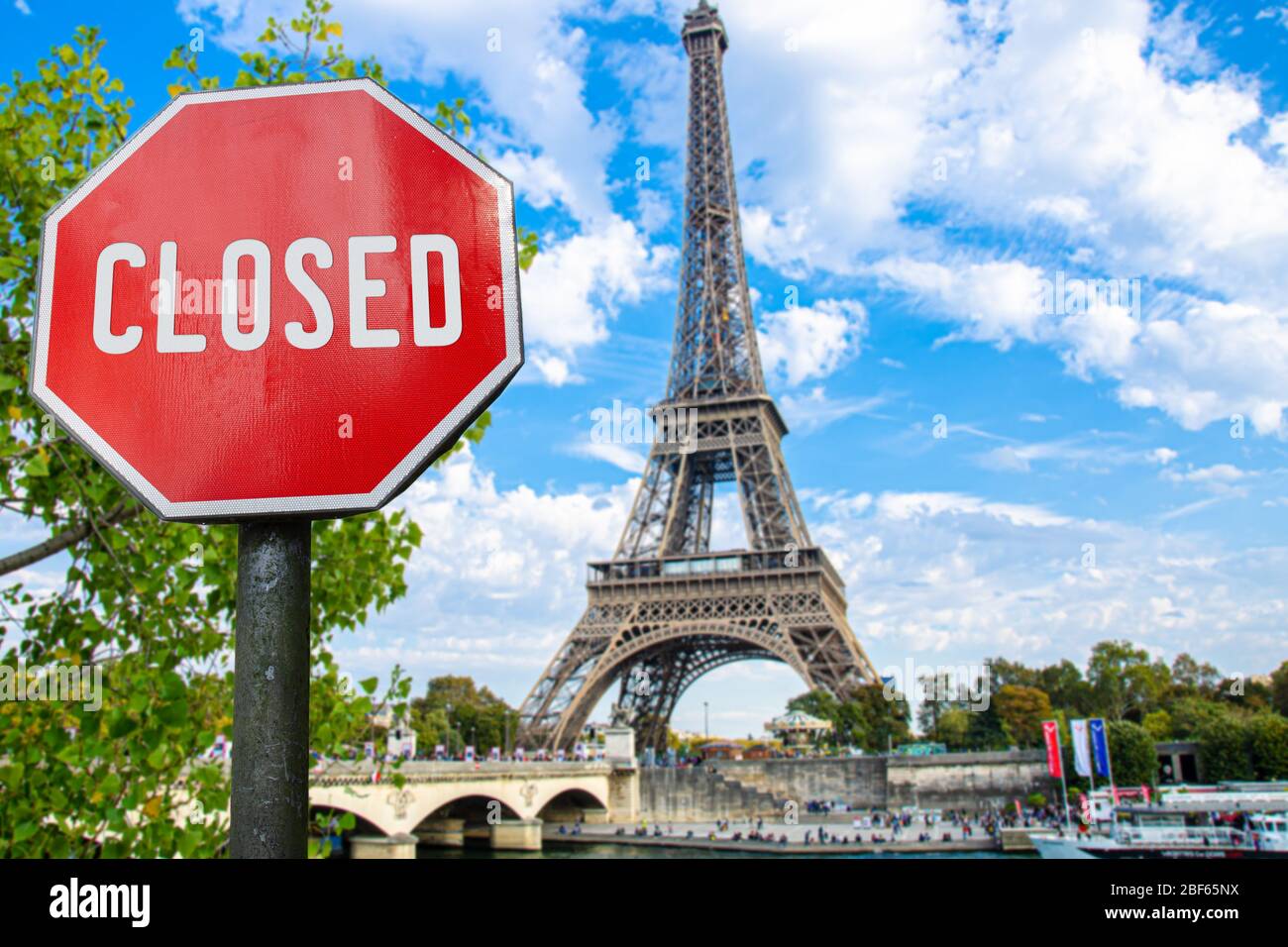 Closed, close stop sign with Eiffel tower background in Paris, France. Closed facilities because of corona virus. COVID-19 pandemic quarantine. Stock Photo