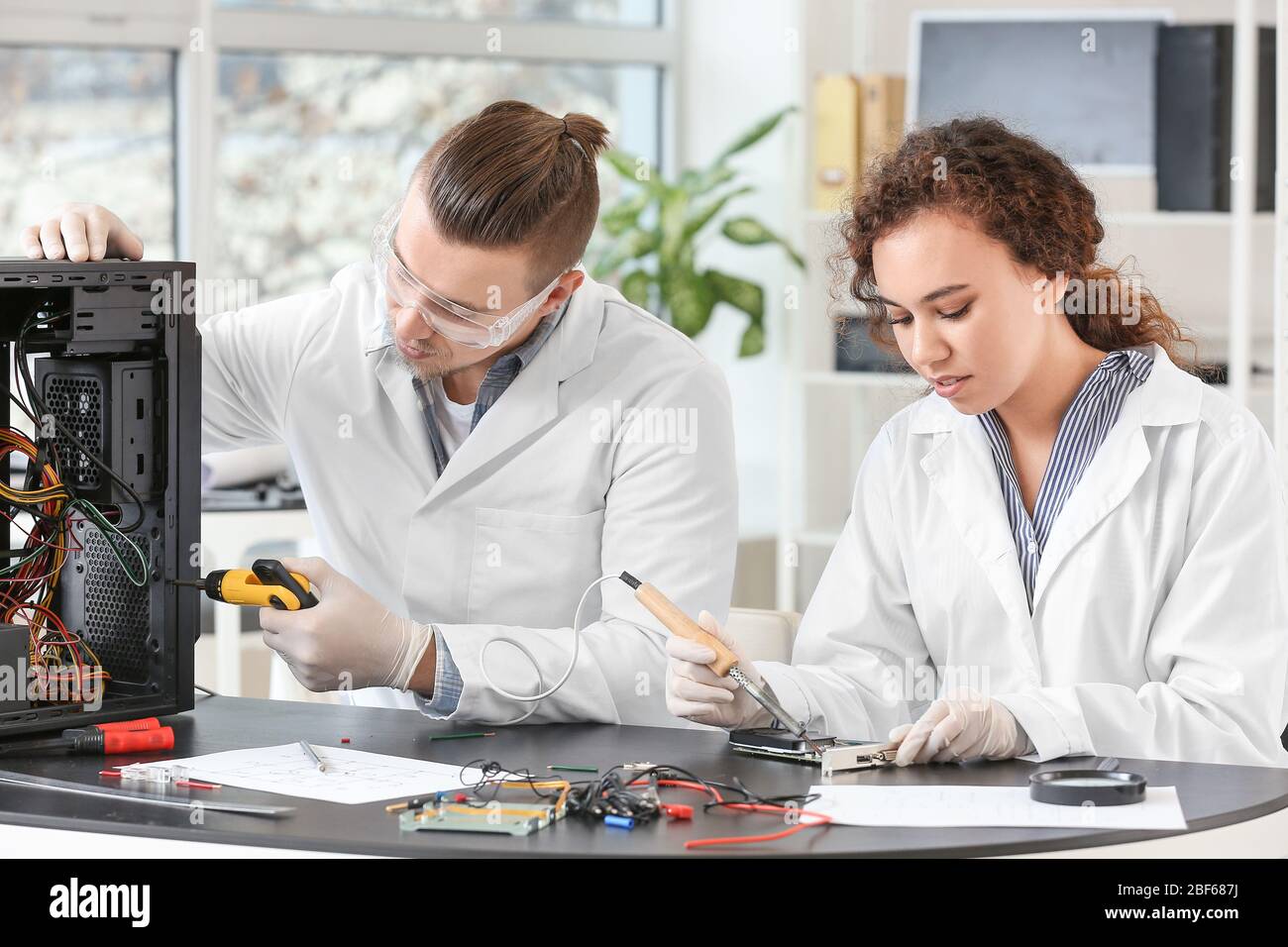Electronic technicians working in service center Stock Photo