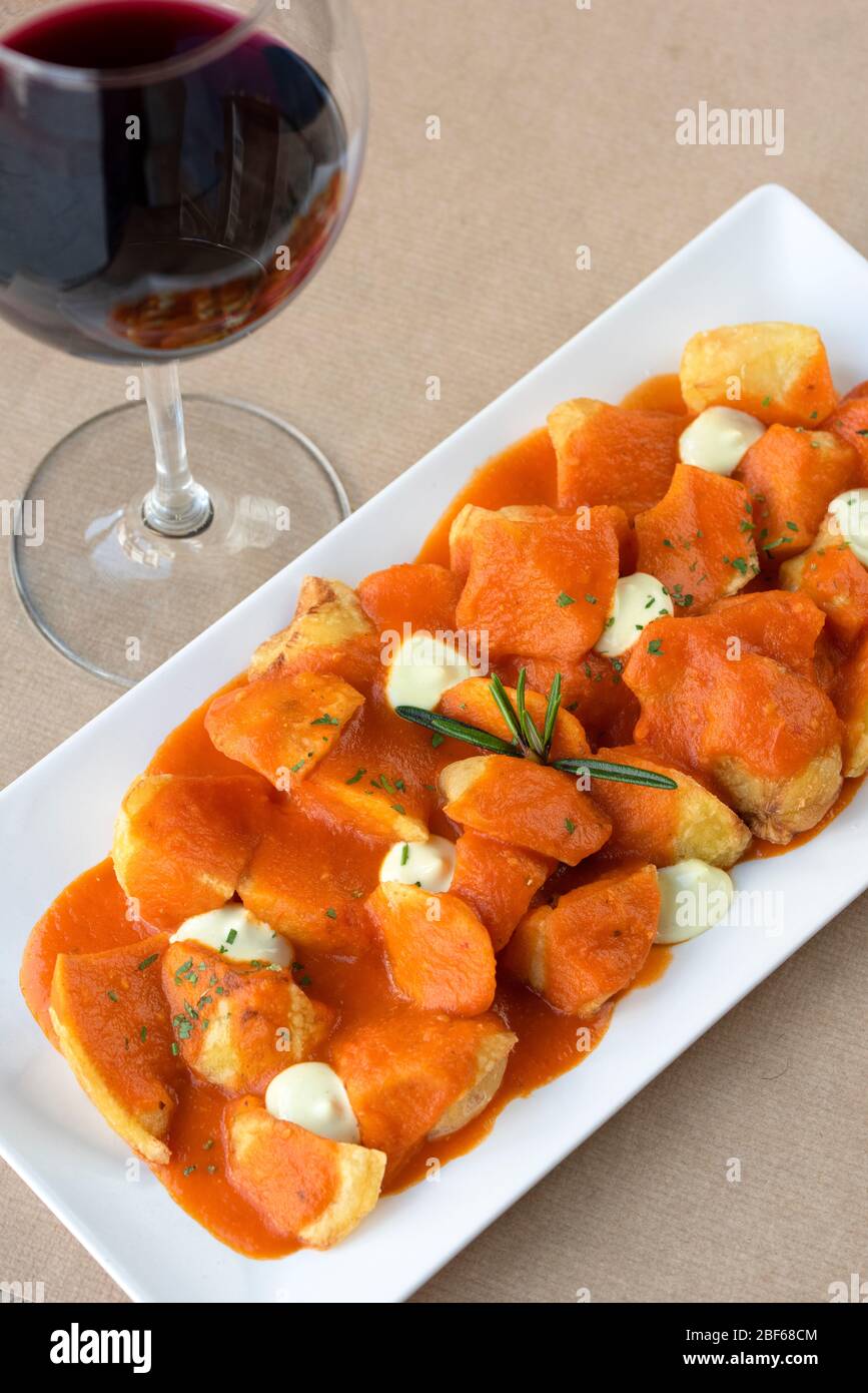 Spanish tapas of Patatas Bravas on a marble table top (Chipped potatoes in spicy tomato sauce