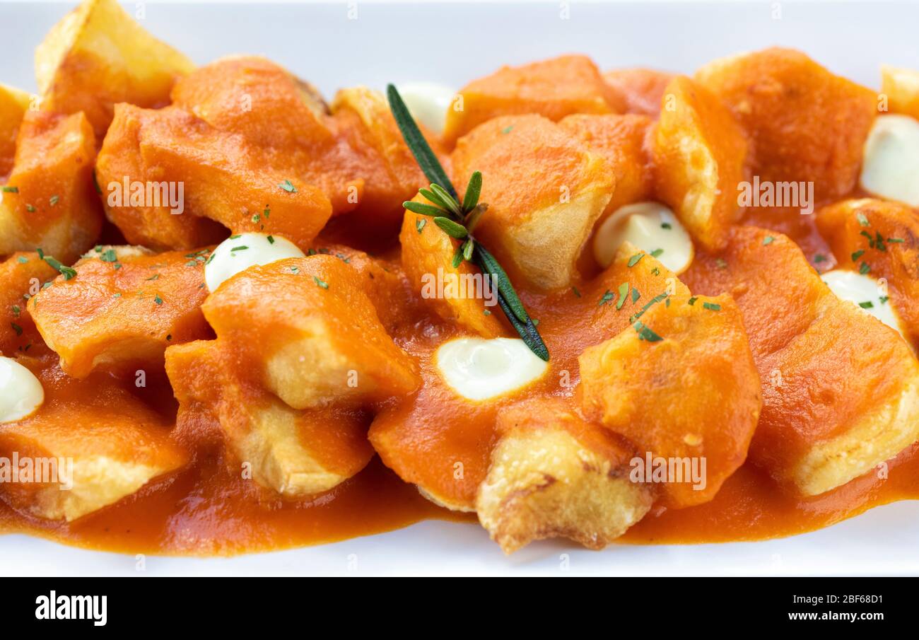 Spanish tapas of Patatas Bravas on a marble table top (Chipped potatoes in spicy tomato sauce), Spain, Western Europe. Stock Photo