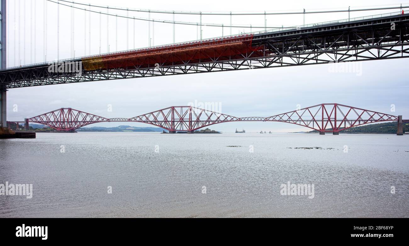 The Forth Railway Bridge (a UNESCO World Heritage Site), viewed through the old Forth Road Bridge, Firth of Forth, West Lothian, Scotland, UK. Stock Photo
