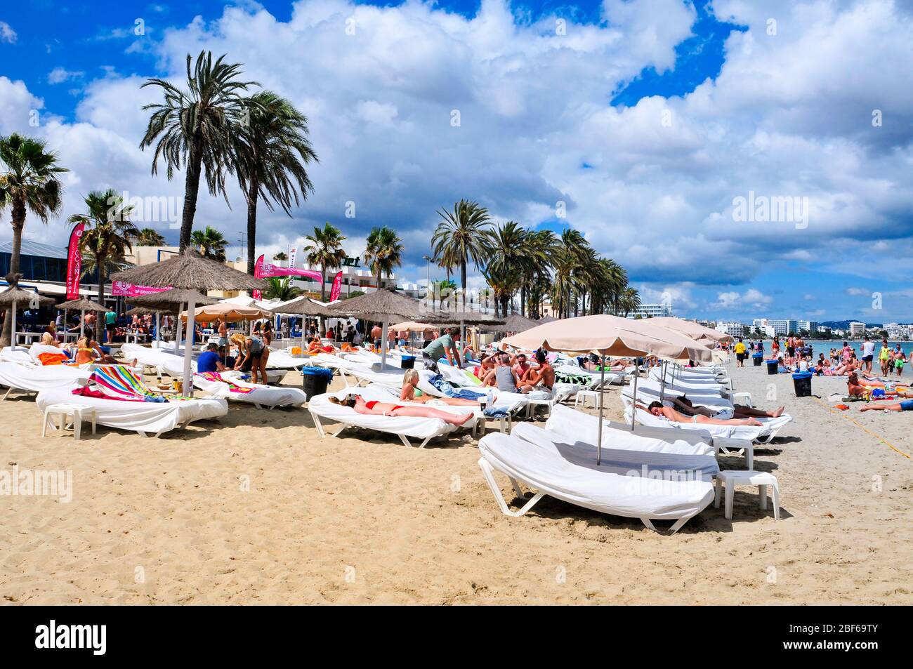 IBIZA, SPAIN - JUNE 16: Sunbathers in the popular Platja den Bossa beach on June 16, 2015, in Ibiza Town, Spain. Ibiza is a well-known summer tourist Stock Photo