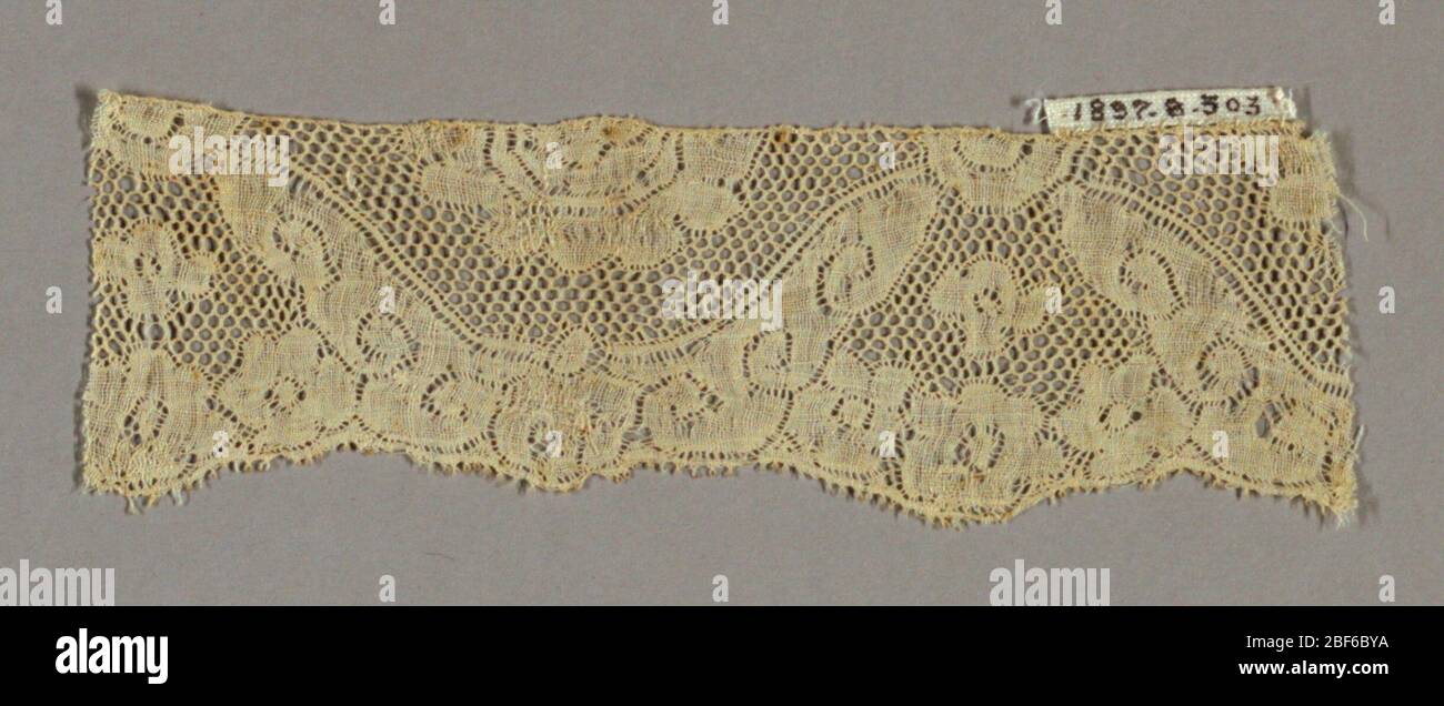 Fragment. Border fragment has a conventionalized design of blossoms and scrolls with round mesh. Stock Photo