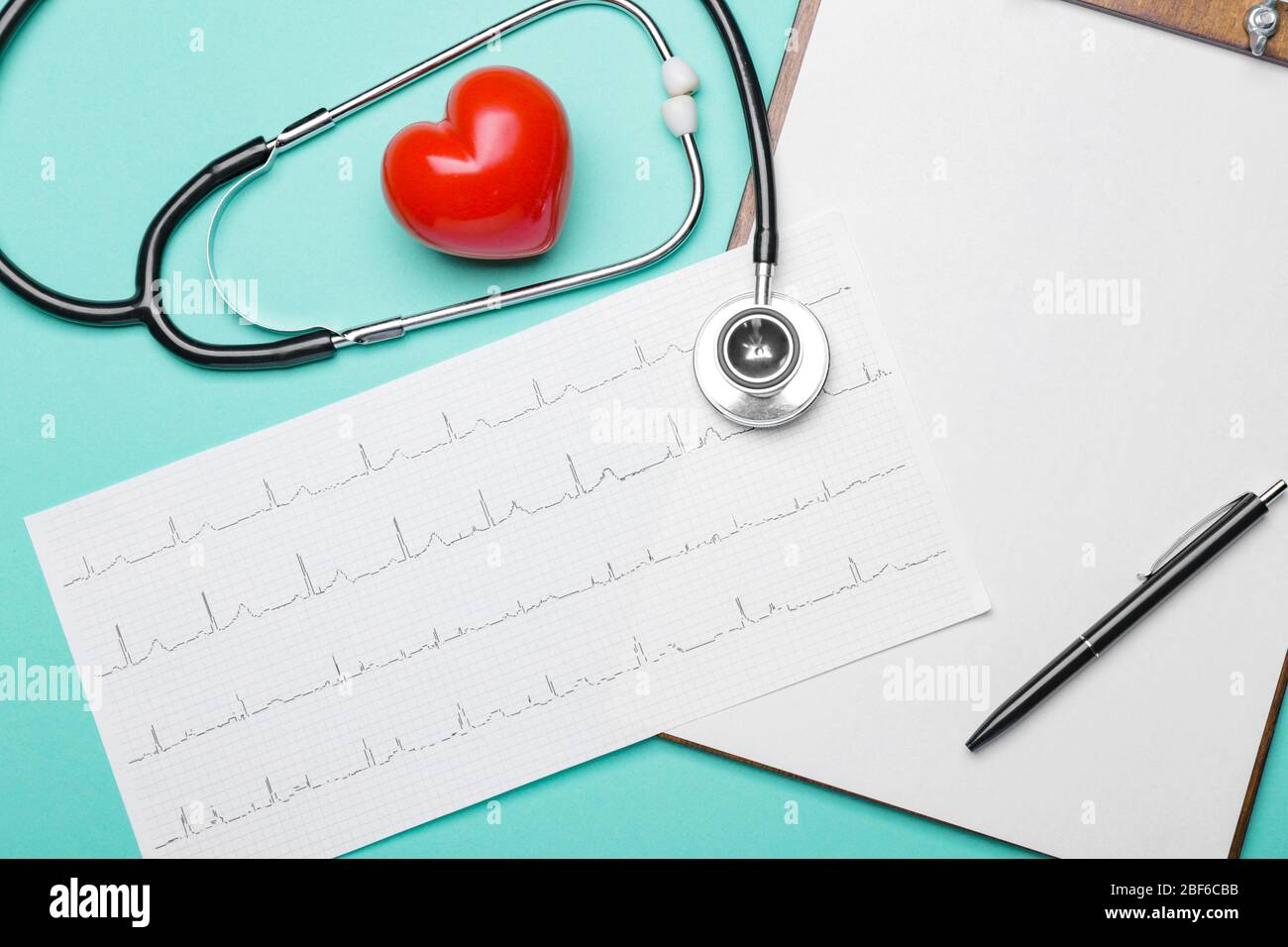 Stethoscope, heart, clipboard and cardiogram on color background Stock Photo