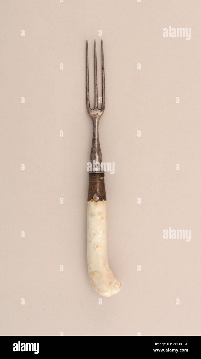 Fork. Three curved tines, rounded shoulders. Baluster-shaped neck. Silver ferrule with scalloped edge. Pistol-shaped handle decorated in relief with floral sprays and a parrot's head at the top of the handle. Stock Photo