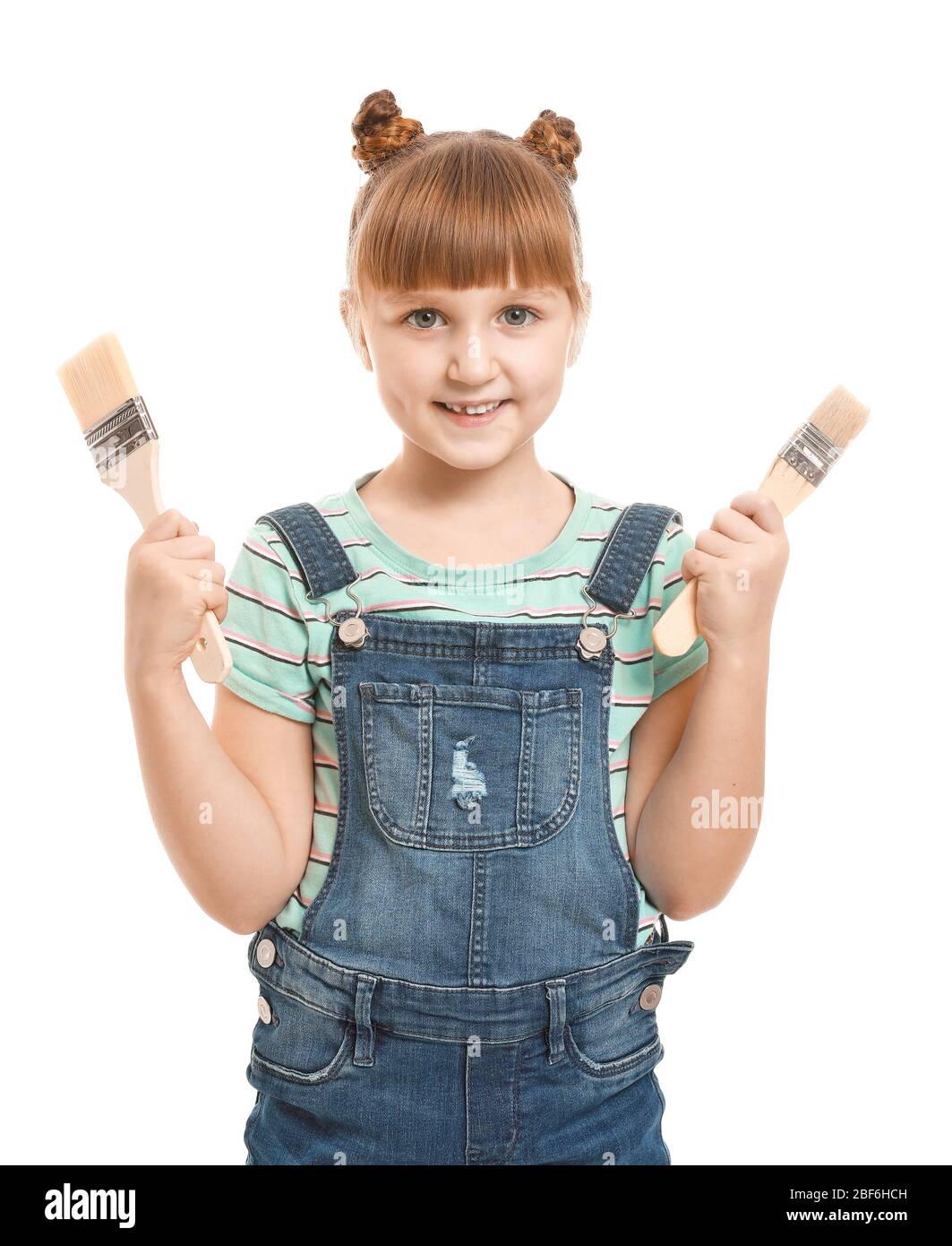 Little girl with paint brushes on white background Stock Photo - Alamy