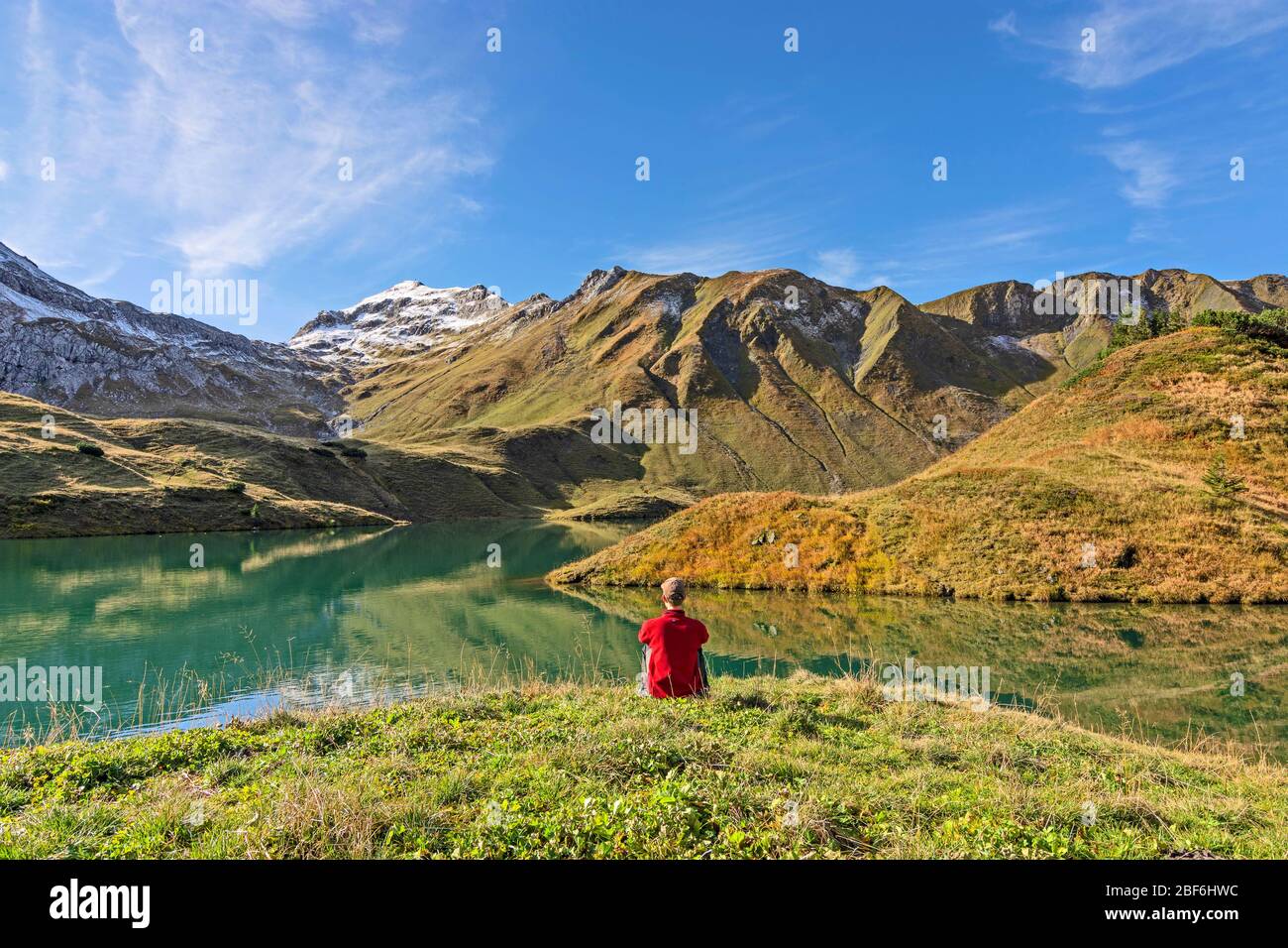 Man sitting at a mountain lake. Allgäu Alps, Bavaria, Germany Stock Photo