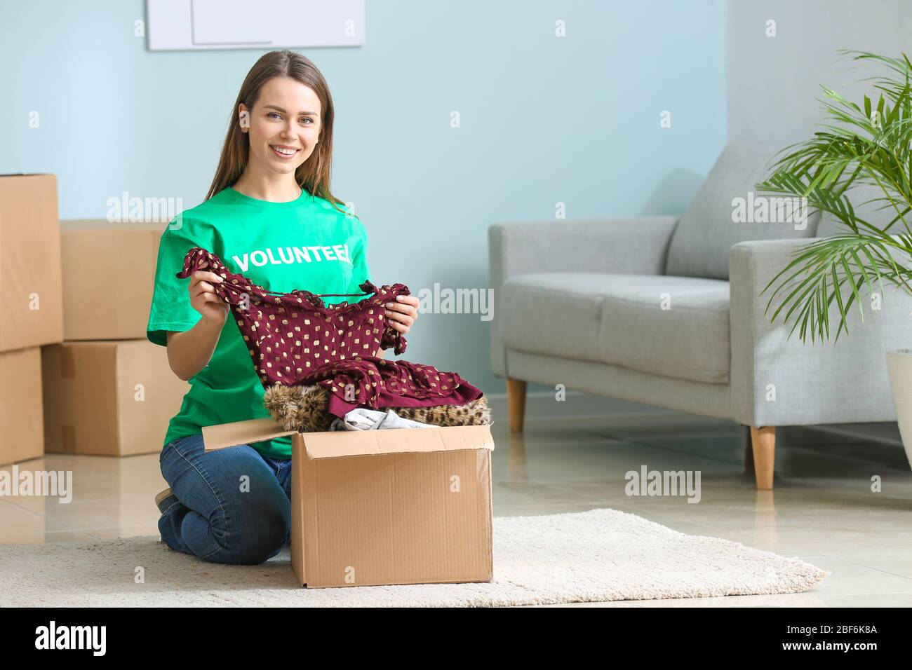 Volunteer packing clothes for poor people in box Stock Photo Alamy