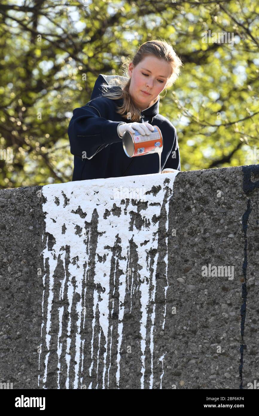 Munich, Germany. 17th Apr, 2020. The artist Janine Mackenroth uses colorful acrylic lacquer to paint an approximately 300 meter long wall near the Leuchtenberg tunnel. The still unfinished work entitled 'Ein Viertel läuft über' (A quarter overflows) is intended to bring colour to the Mittlerer Ring over an area of around 800 square metres. Credit: Felix Hörhager/dpa/Alamy Live News Stock Photo